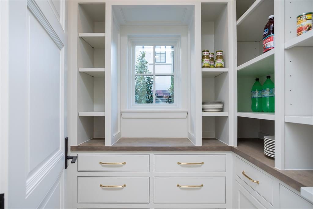 The pantry is spacious and bright with adjustable shelves and tray storage. 