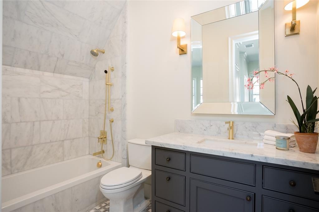 The secondary bath is tranquil with Carrera marble counters and marble walls. 
