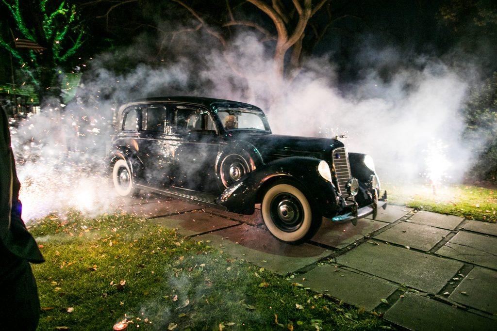 The bride and groom make their exit in a 1938 Lincoln Wiloughby Limousine — one of only five built (Photo by Samuel Lippke Studios)