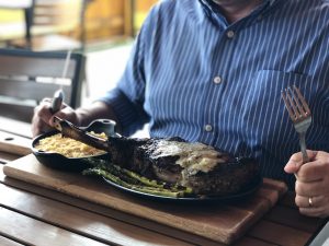 The gourmet Father's Day special at PINSTACK with a Tomahawk steak, truffle mac & cheese, and grilled asparagus; photo courtesy of PINSTACK