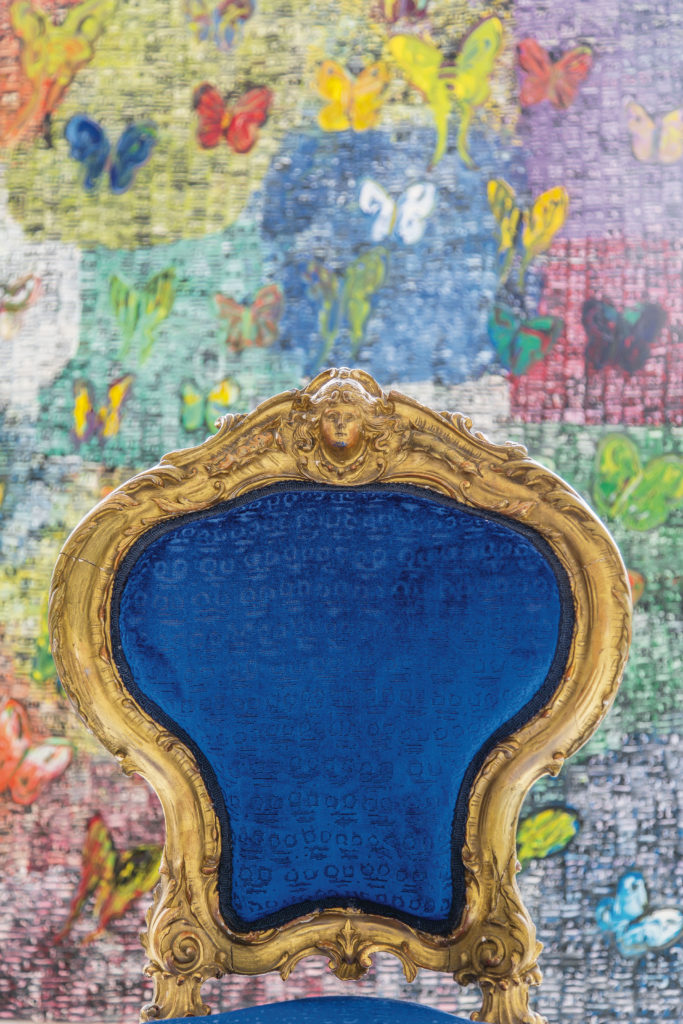 A gilded Italian chair, covered in the artist's Guardians fabric for Lee Jofa, stands in front of a  painting bearing scores of butterflies. (Photo Marco Ricca)