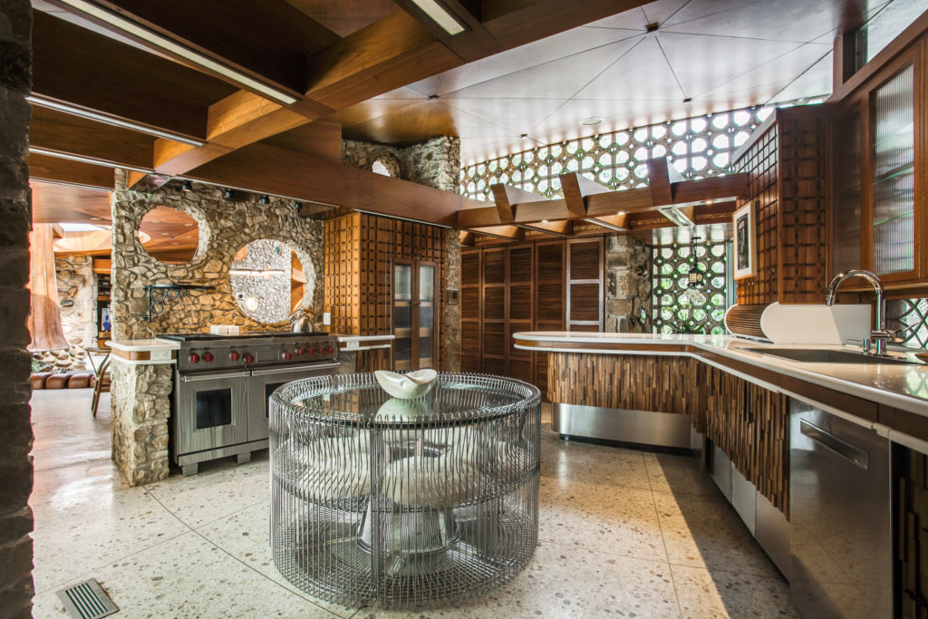 The kitchen features natural stone and walnut paneling.