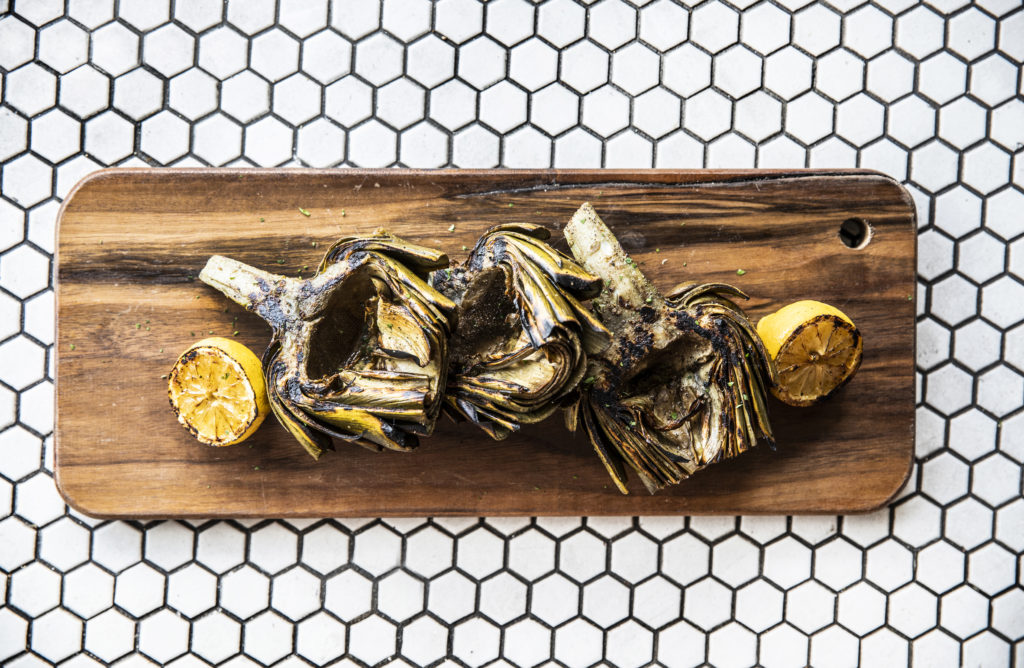 Relish's whole grilled artichoke with fresh herbs and lemon aioli is no ordinary happy hour fare. (Photo by Julie Soefer Photography.)