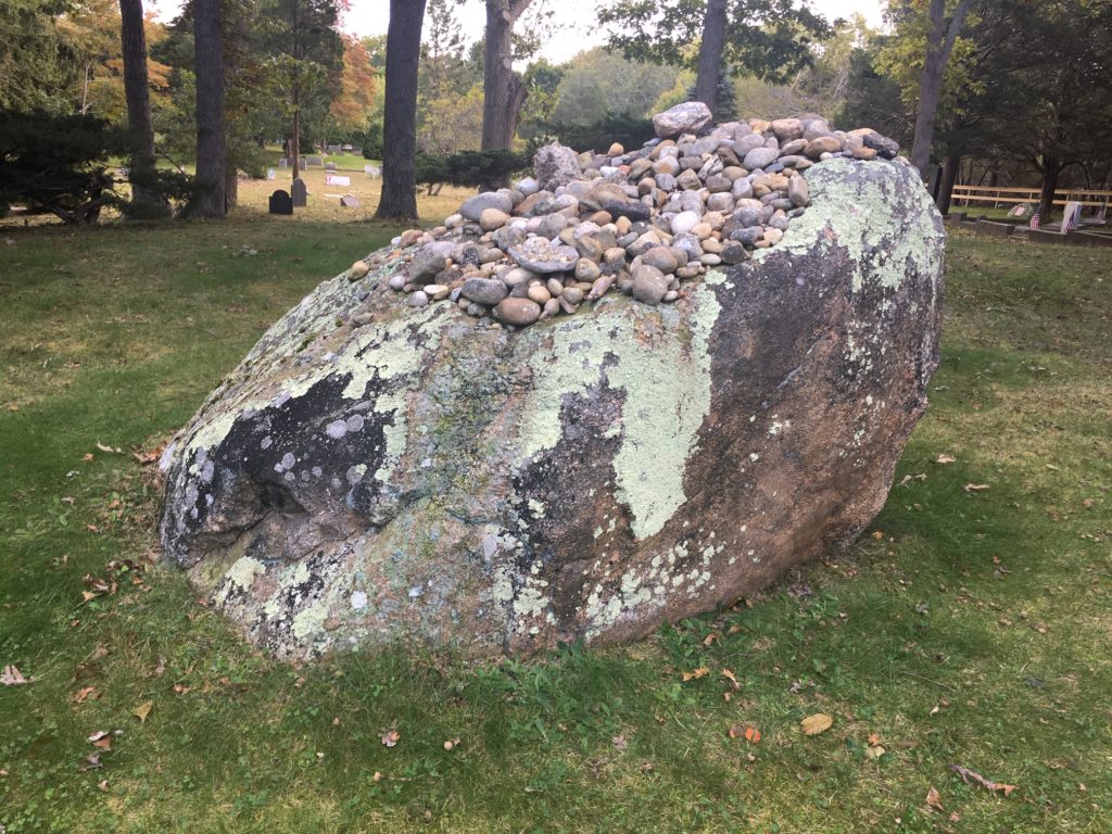 View of the back of Jackson Pollock's grave. The lichen- covered boulder is the polar opposite of pristine statuary of angels and saints that typically figure in funerary art. The massive natural stone is a fitting memorial for this larger-than-life painter whose talent could not be restrained.