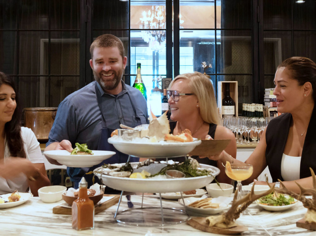 The cozy six-seat chef’s counter at State of Grace in River Oaks faces a hearthstone fire.