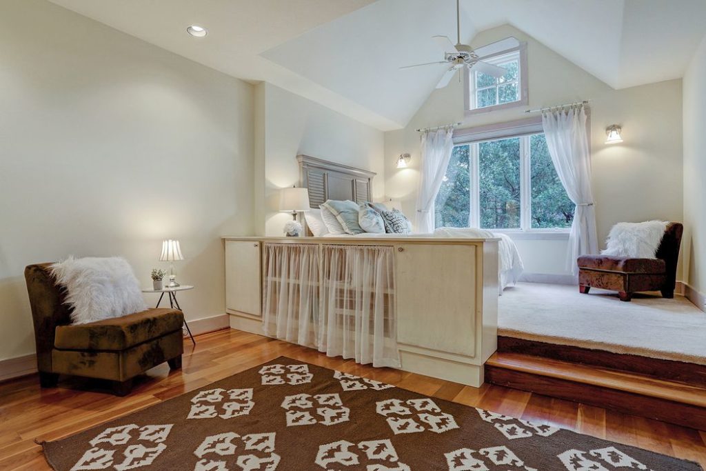 The bed's space by the window opens up the room and invites an enticing view of the neighborhood. 