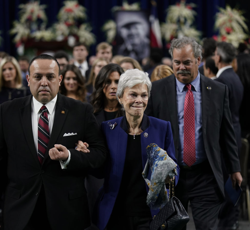 Jerry Reyes, with the Geo. H. Lewis & Sons funeral home, escorts widow Janice McNair, followed by her son Cal McNair, after a public celebration of life for Houston Texans owner Robert C. McNair at NRG Stadium. (AP Photo/David J. Phillip, POOL)