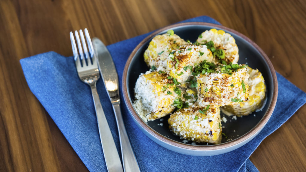 Blanco puts a twist on their creamy street corn, serving it on the cob. 