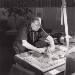 Bruce Goff in his Price Tower studio, Bartlesville, Oklahoma, circa 1960s. The architect was a master also at painting and the applied arts, often including his own canvases, sculpture, and glass or mirror mosaic elements in the interiors of the buildings he designed. Shown here, he is at work on a mosaic panel.