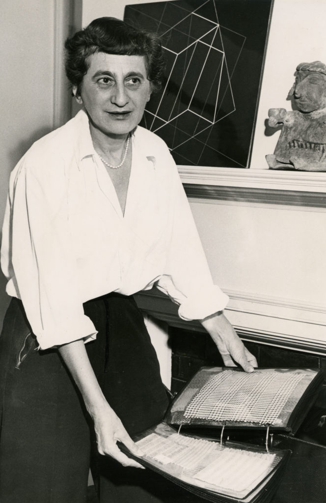 Anni Albers with textile samples in her New Haven home, circa 1950 - 1960.