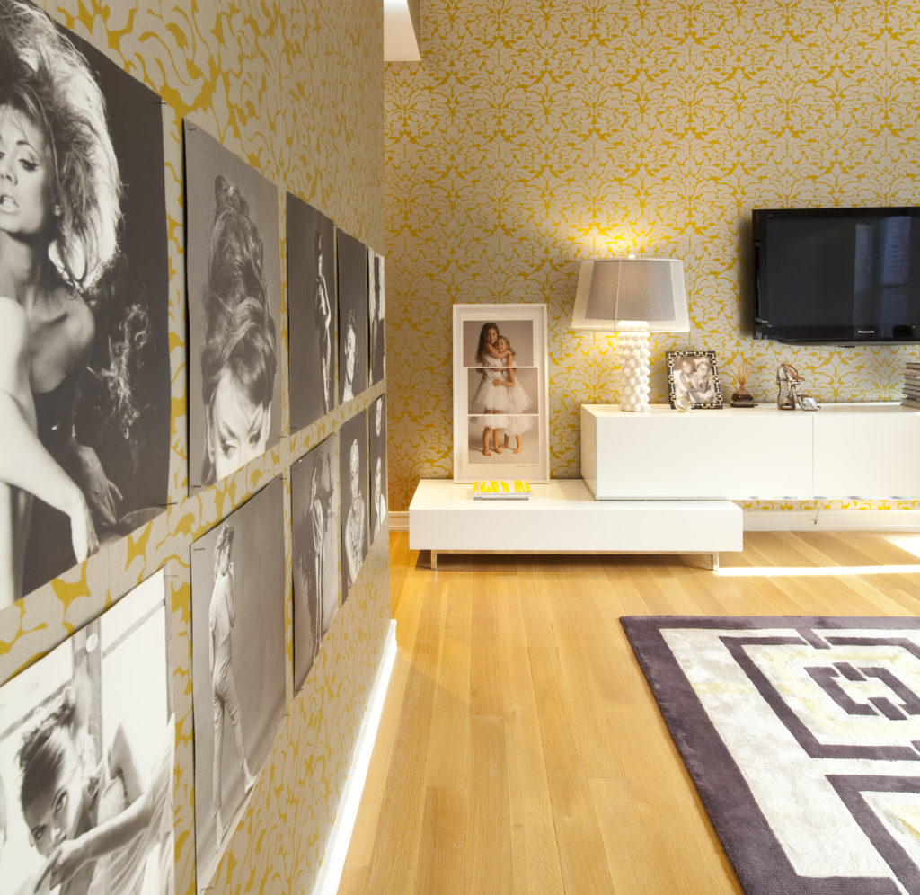 Another view into the master bedroom where a second wall features photographs of burlesque dancers. (Photo by Julie Soefer)