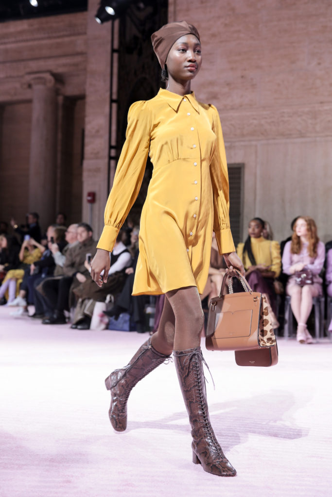 Kate Spade New York yellow silk shirtdress, brown turban and brown lace-up boots, clutch, and handbag with faux leopard trim. (Photo by Kate Spade New York)