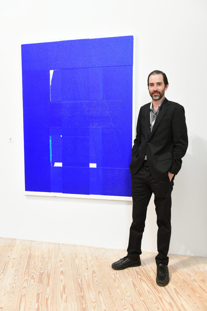 Will Boone with his live auction canvas "Threat," 2018, at the 2019 CAMH Gala and Art Auction. The former Houstonian/now L.A. artist will exhibit this fall (November 8, 2019 – February 16, 2020) at the museum where he once worked as an art handler. Boone generated a bidding war over the phone for his text-based monochrome painting. (Photo by Daniel Ortiz) 