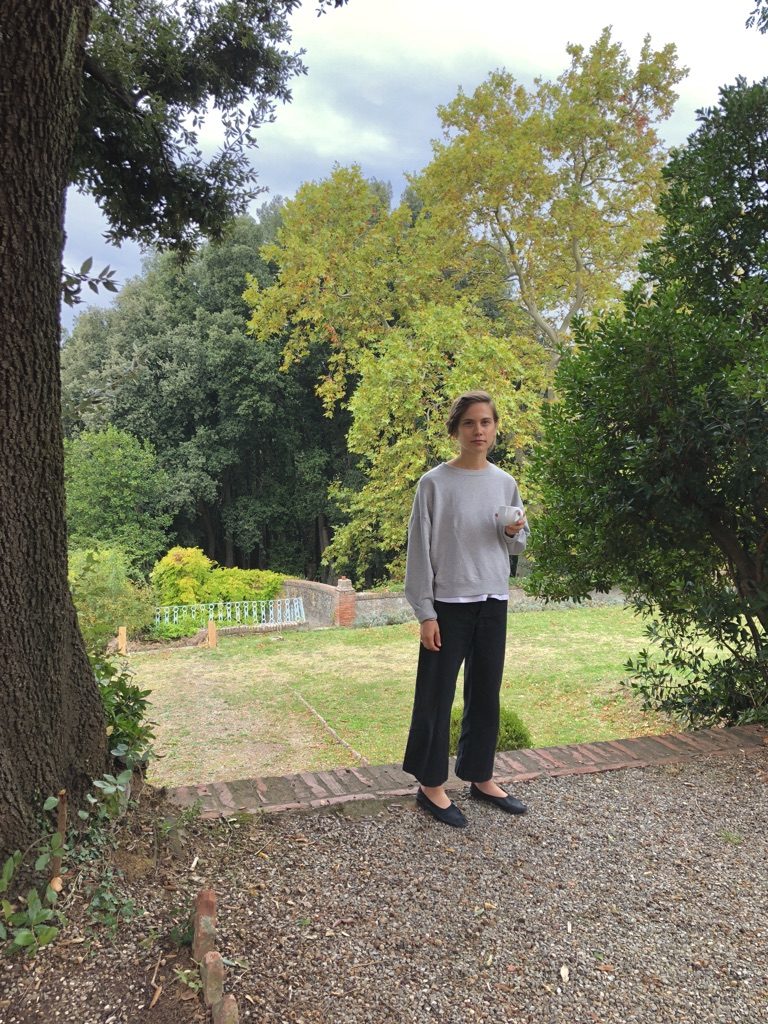 Fellow resident and Texan Leigh Patterson, a creative based in Austin, enjoys afternoon tea in the villa's bountiful garden. (Photo by Bradley Kerl)