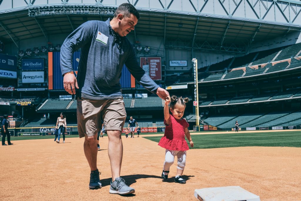 Joe Heil assists his daughter, Allison, as she works the bases at Minute Maid Park during the Texas Children's Hospital Family Fun Day. (Photo by Chin Phan)