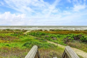 Across a green stretch, the wide beach and Gulf Coast waves of Beachtown await salt water fans. (Photo by TK Images)