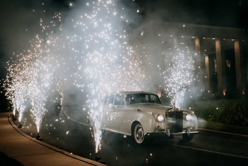 Amid sprays of fireworks, the newlyweds depart in a vintage Rolls Royce. (Photo by Philip Thomas)