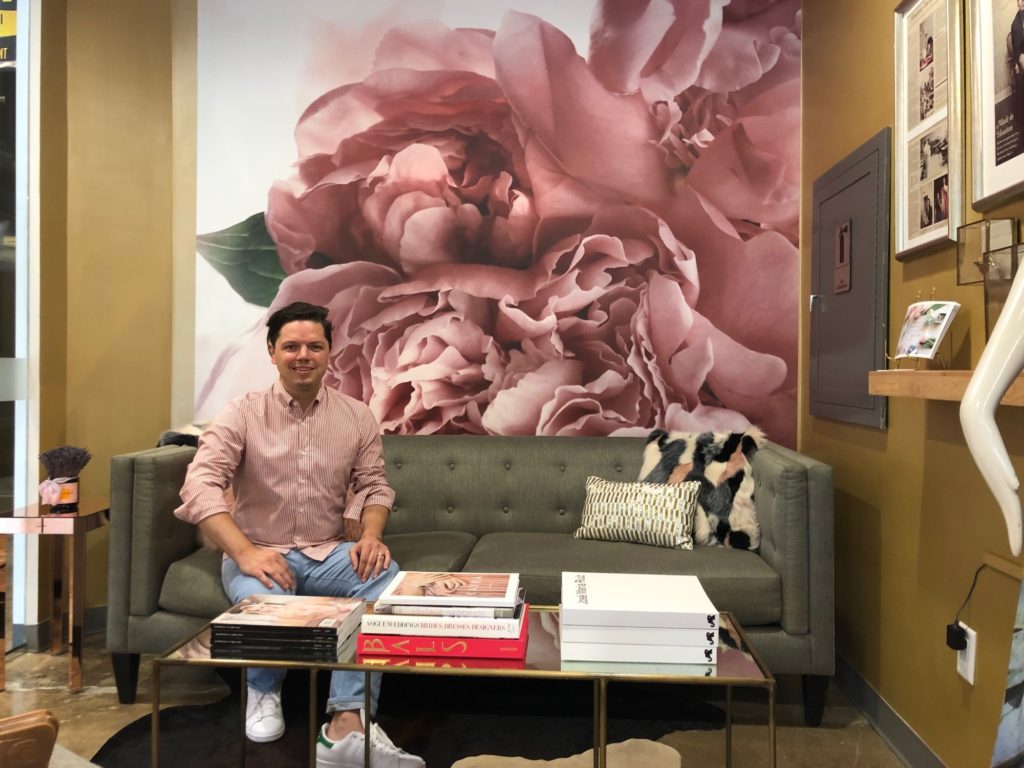 Designer David Peck in his showroom where one of his fabric designs has been translated into a wall mural, one aspect of his latest exercise in creativity.