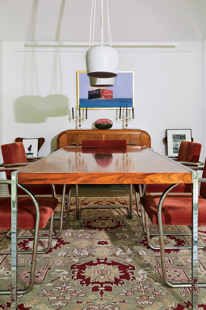 In the dining room, finds from the much-missed Houston mid-century dealer Metro Modern hold court: rosewood-and-chrome table/desk, part of Richard Schultz’s desk collection originally designed for Knoll in 1963, rimmed by Brno chairs originally designed by Ludwig Mies van der Rohe and Lilly Reich in 1929-1930. (This particular set, manufactured in 1981, is covered in the original rust-red mohair). Sculptural AIM ceiling light designed by the Bouroullec Brothers for Flos, 2013. Galveston artist Leslie Sanders’s maritime painting "Outbound," 2014. (Photo by Pär Bengtsson)