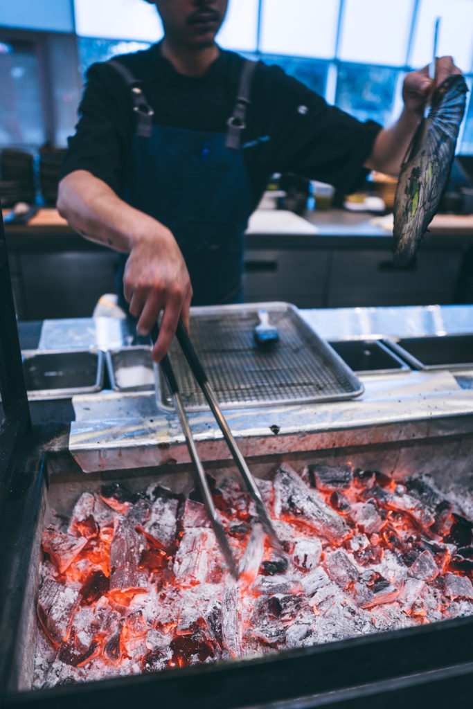 Live coals provide Roka Akor dishes with a unique grilled flavor. Notice the fan in chef Jason Phan's hand.