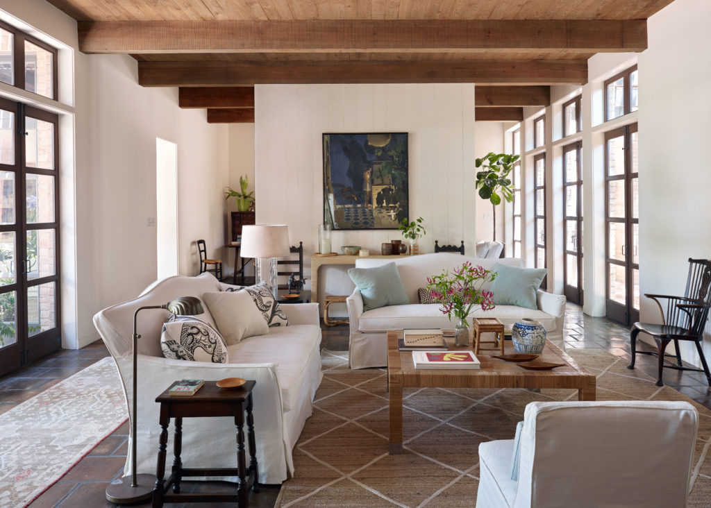 The living room of an exuberant Houston home designed in 1977 by architect I. W. Colburn. Interior design Tom Scheerer. Sangram Majumdar painting, vintage Bielecky coffee table. Saltillo tile floors are original to the home.  (Photo by Francesco Lagnese)