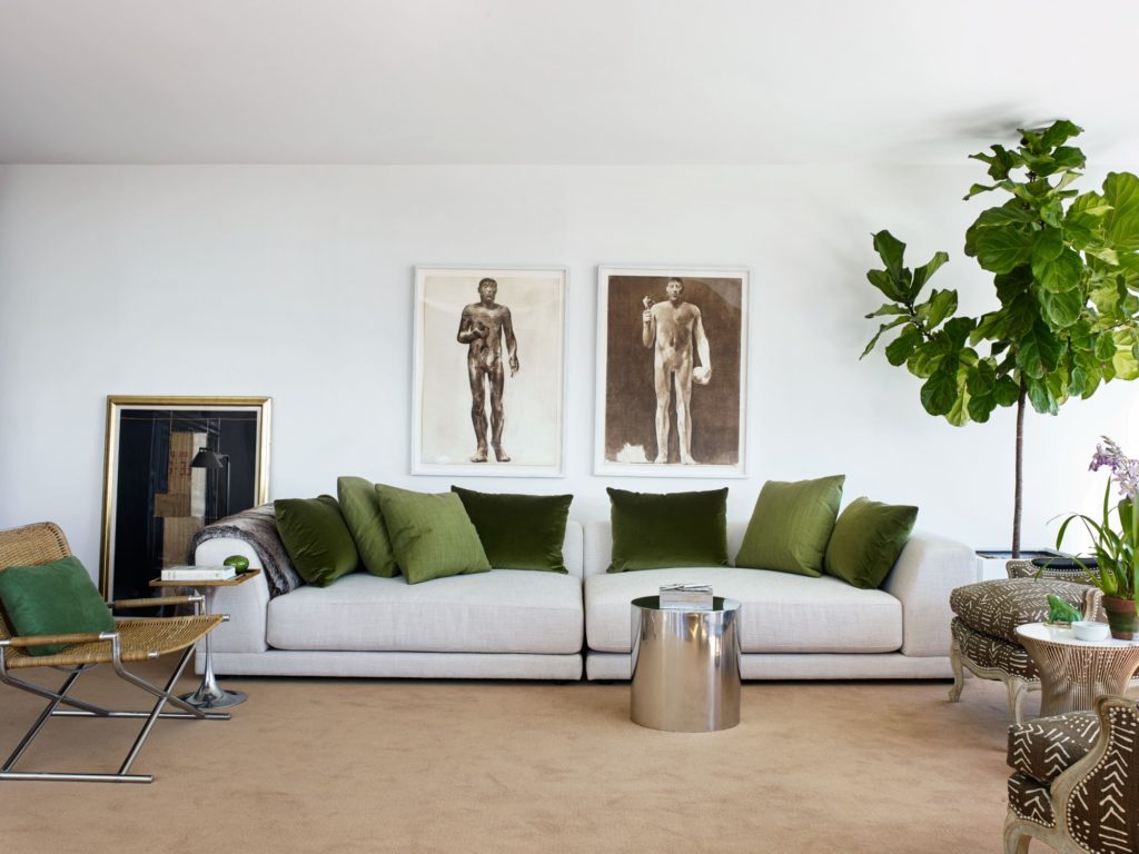 In Tom Scheerer’s NYC home in a Miesian-style highrise, the living room sofa is from CB2; 1970s Luciano Morti gouaches. (Photo by Francesco Lagnese)