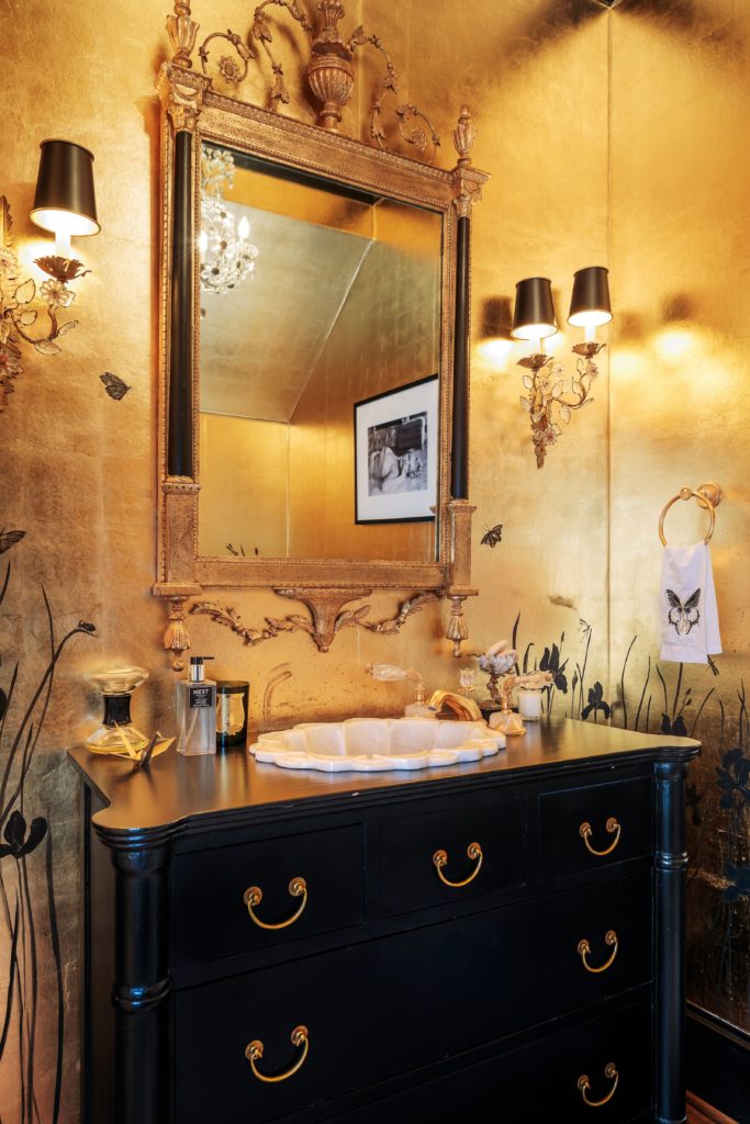 The powder room features scalamande gold leaf wallpaper with custom hand-painting. 