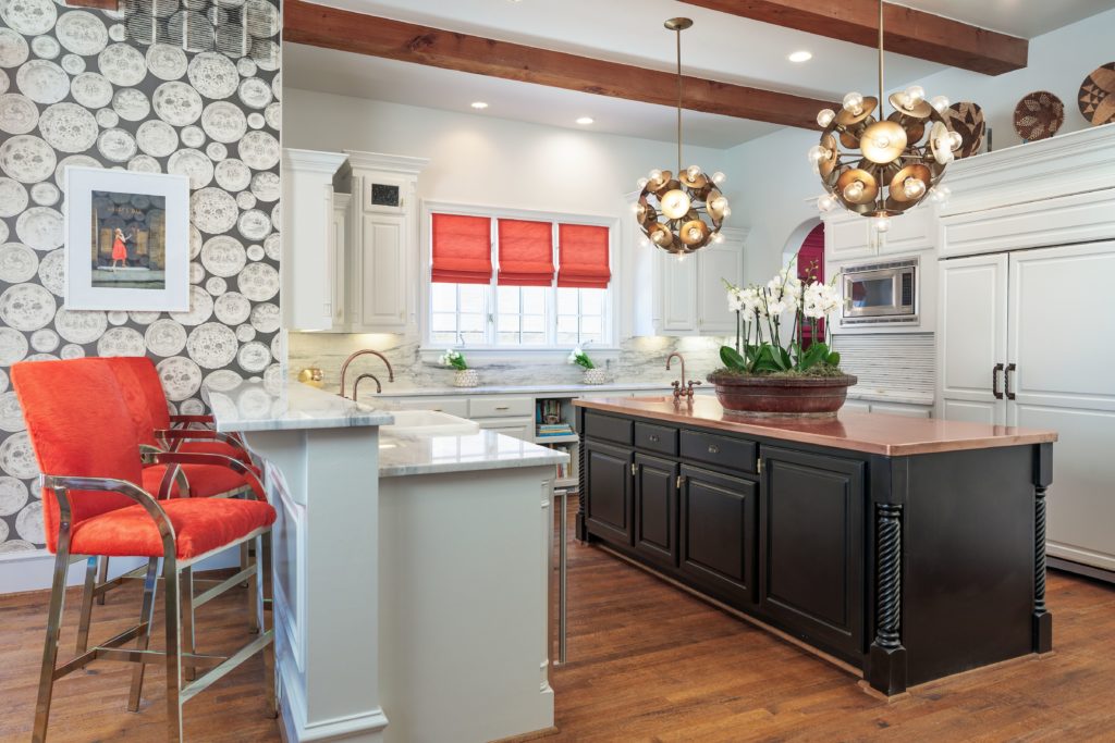 The kitchen features delicate wallpaper and gleaming marble. 