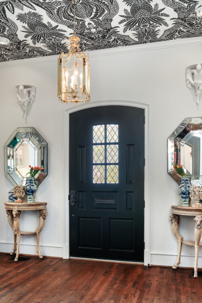 The entry opens into a room with soaring ceilings boasting a graphic black and white pattern. 