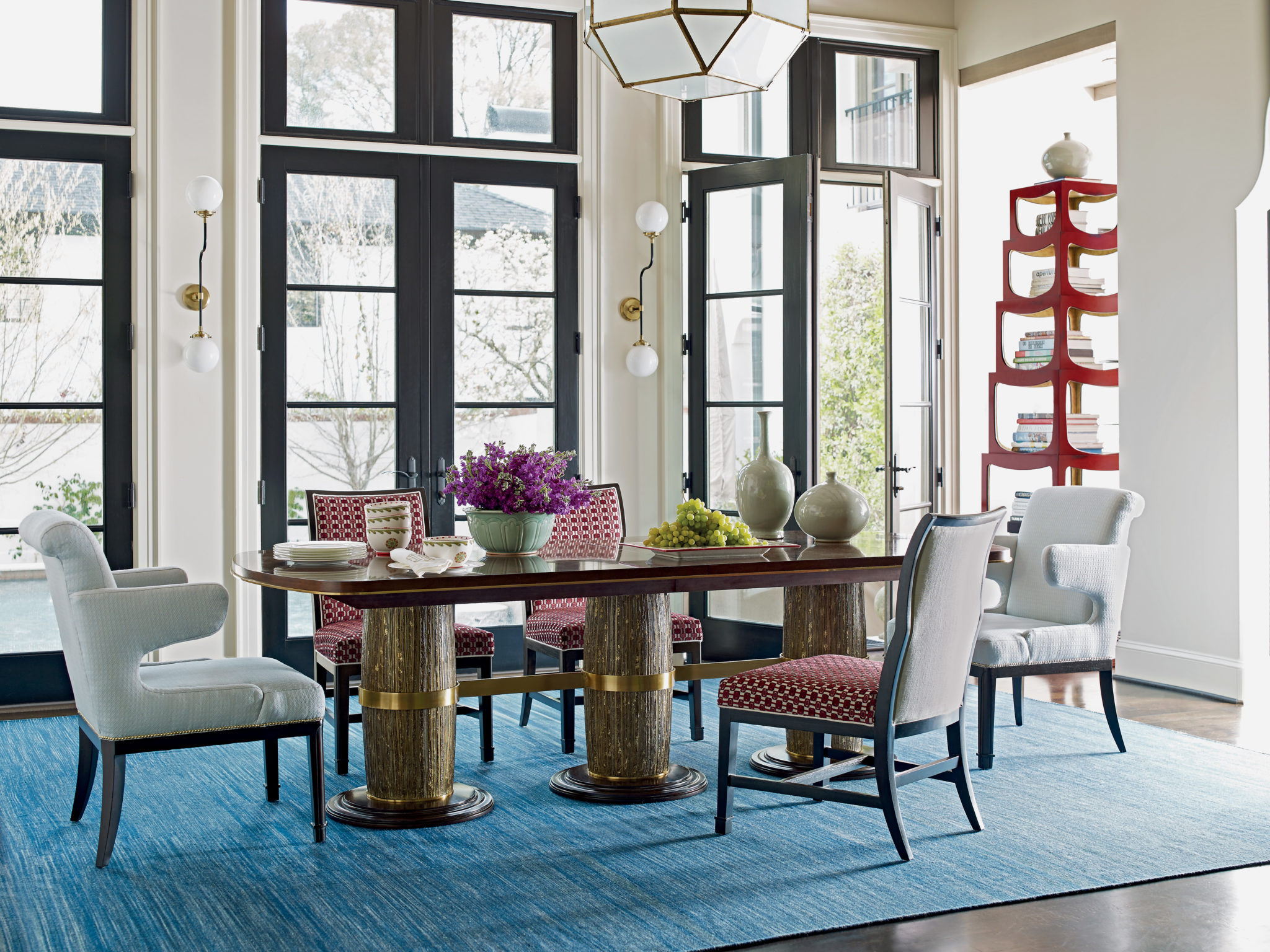 This dining room table is dressed with decorative elements and breaks the rule of having matching chairs to make it less intimidating to use in everyday life.