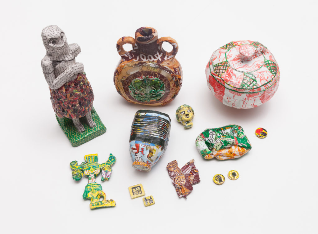 Artifact-inspired works from Michael Rakowitz's series "The Invisible Enemy Should Not Exist (Lamassu)," 2007 to ongoing, a collection of drawings, cardboard and newspaper, sculptures, museum labels, sound. (Courtesy the artist)