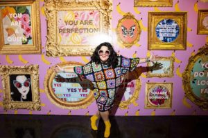 Ashley Longshore poses in front of her art installation wall at New York Fashion Week