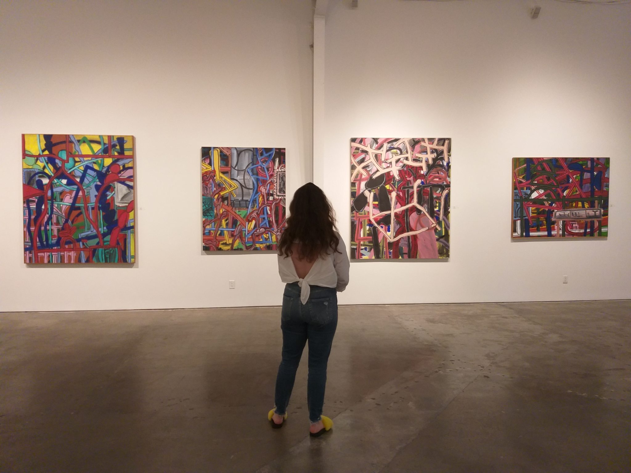 Gallery assistant director Lauren Arocha contemplates Perry House’s work at the artist’s tribute exhibition, August 2019 at Deborah Colton Gallery. (Photo by CDA)