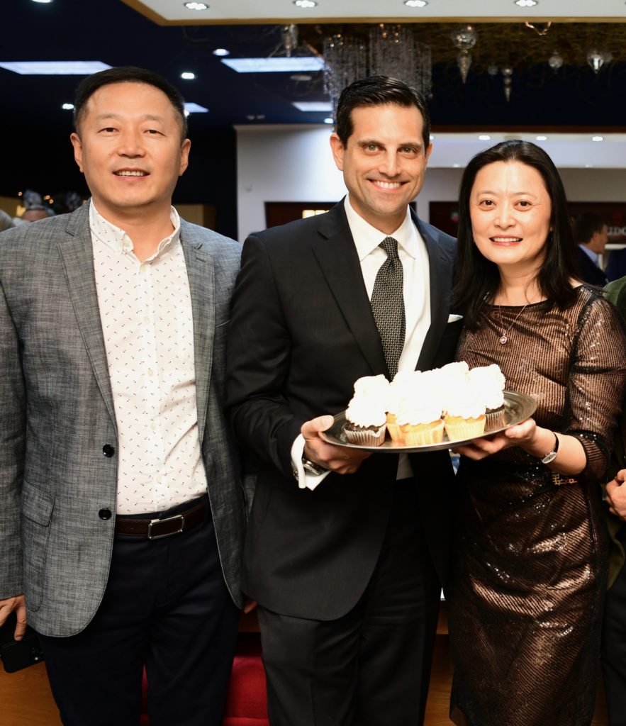 Jonathan Zou, Jonathan Zadok and Christine Zou intrigued by the jewel-filled cupcakes at Zadok Jewelers holiday party.  (Photo by Daniel Ortiz)