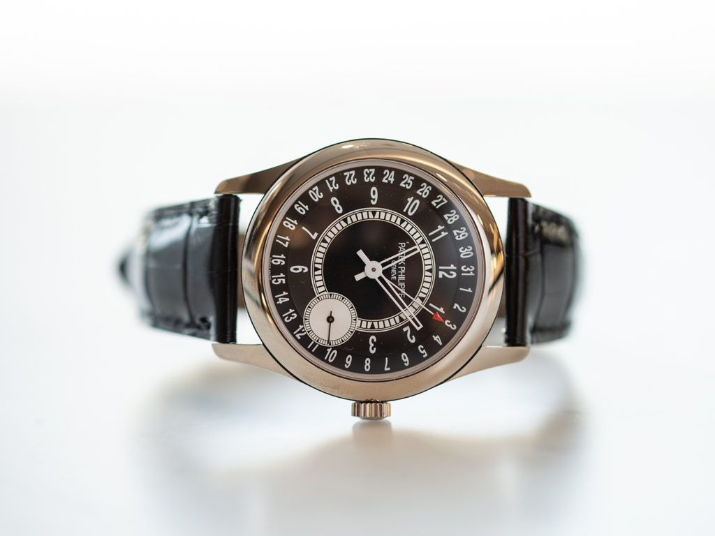Iconic Patek Philippe 18K gold Calatrava watch with date indicator and offset seconds dial.