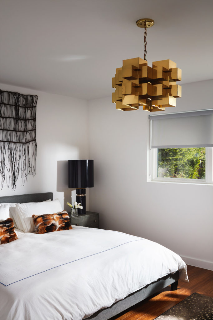 In the master bedroom, Brutalist 1970s chandelier attributed to Gaetano Sciolari, and ceramic 1970s lamp from James McInroe. (Photo by Lisa Petrole)