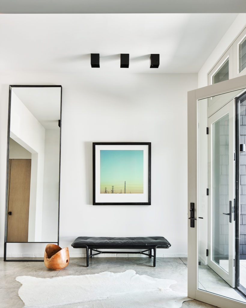 In the entry, raw-steel mirror from Chad Dorsey Design. Vintage McGuire bench. Kyle Warren photograph. (Photo by Stephen Karlisch)