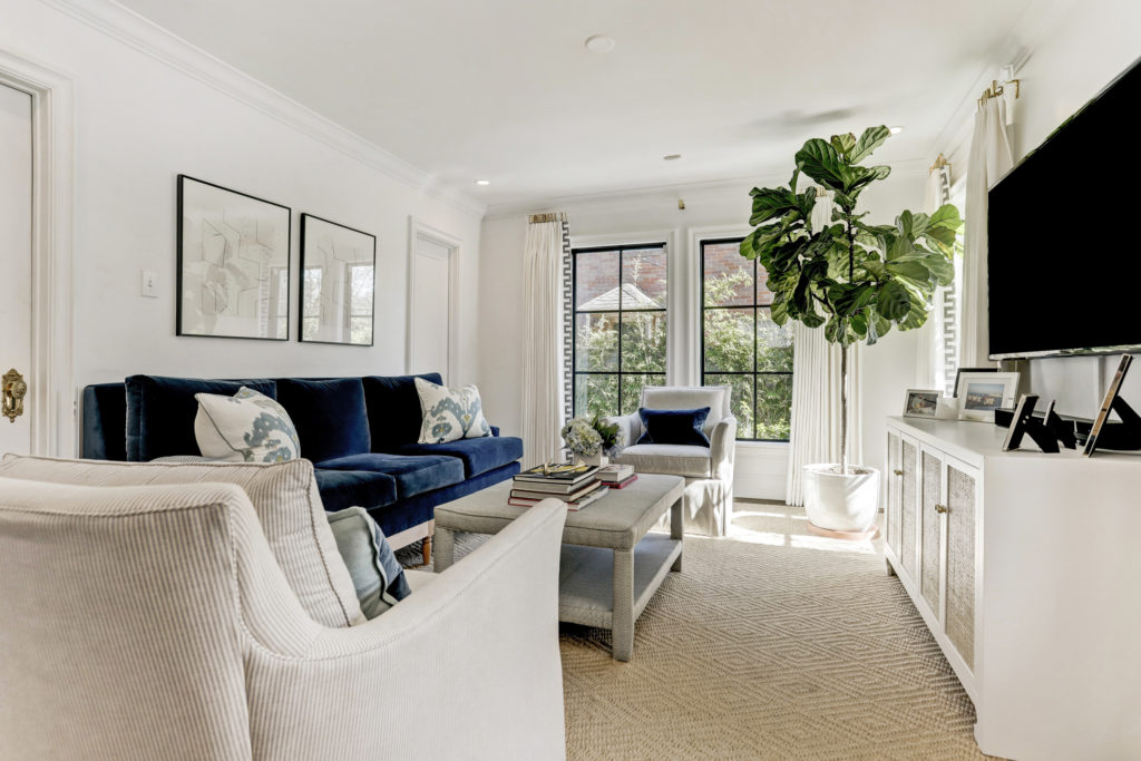In the family room, the sofa and ottoman are custom. The armchairs are from Highland House, and the console was found at Made Goods. (Photo by TK Images)