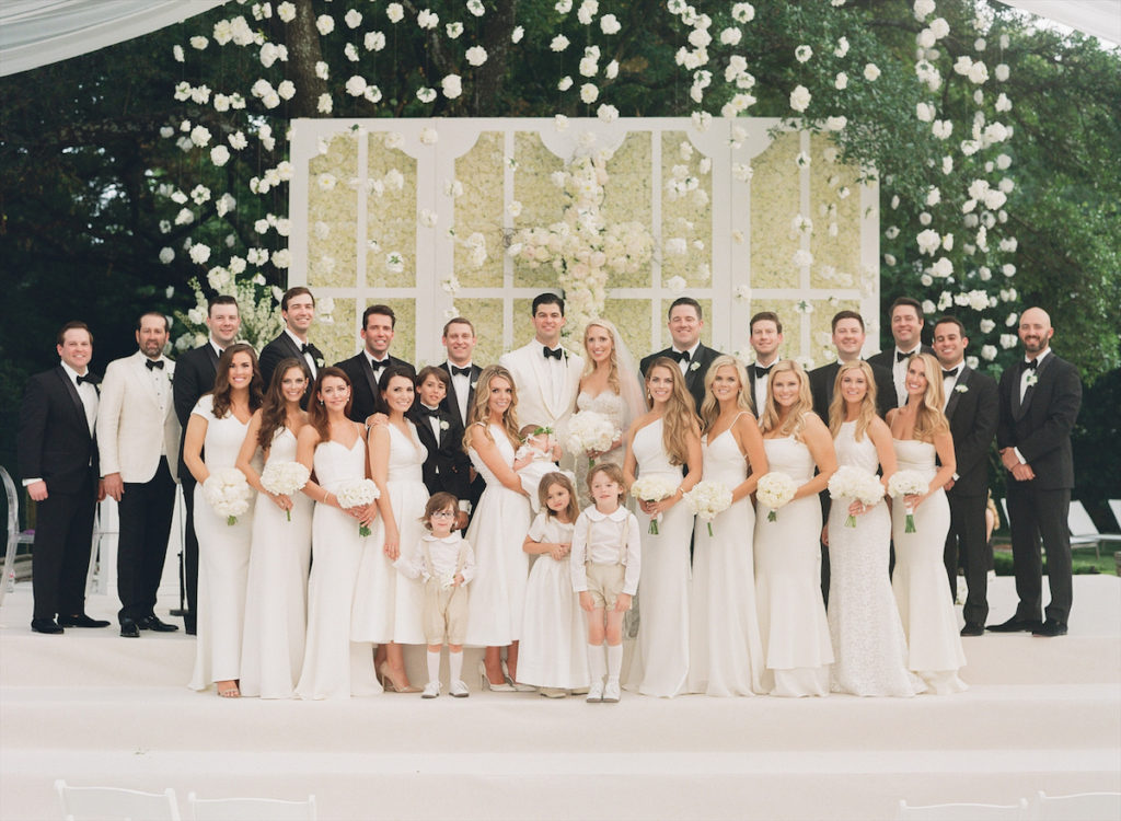 To complement the bride’s Monique Lhuillier gown, the 10 bridesmaids — including both of Krystal’s sisters — each wore a different style white gown. (Photo by John Cain)
