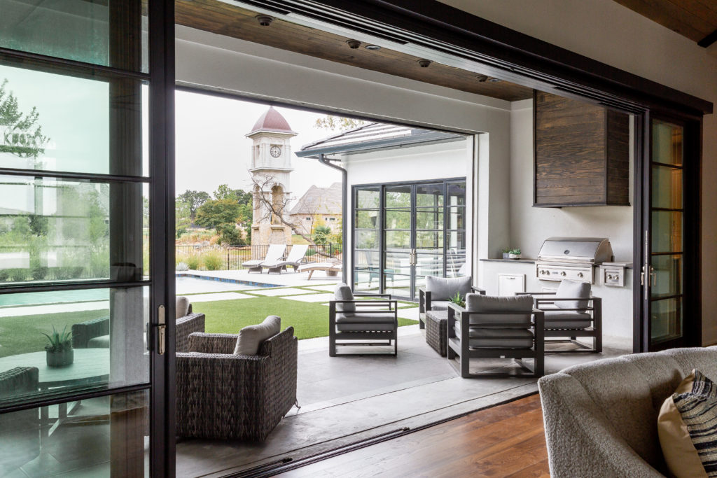 Outdoor furnishings from Rattana and Globalviews  invite indoor/outdoor living through the open glass wall. (Photo by Jen Burner)