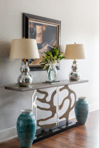 The console from Ambella with lamps from Visual Comfort stand across from the wine cellar and leads to the living room. (Photo by Jen Burner)