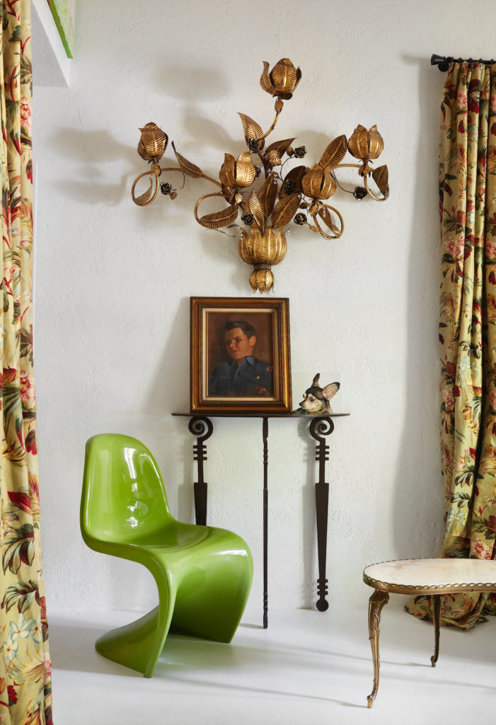 The bedroom's sitting area with a green Verner Panton chair, antique Italian sconce, and iron table by artist Stuart Kraft. The Chihuahua painting is by a fan of Aldridge's blog. (Photo by Lisa Petrole)