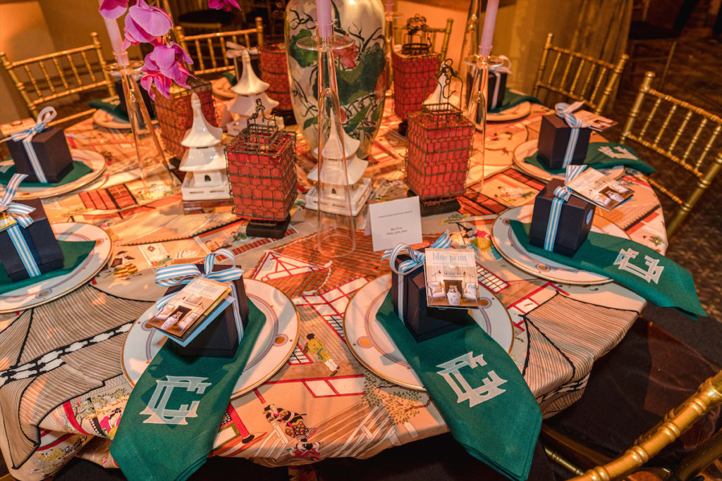 The Blue Print team blended vintage lavender and white china from the Hotel Meurice in Paris, colorful Manuel Canovas fabric, chinoiserie accents, and emerald-hued monogrammed napkins for an impressive display. 