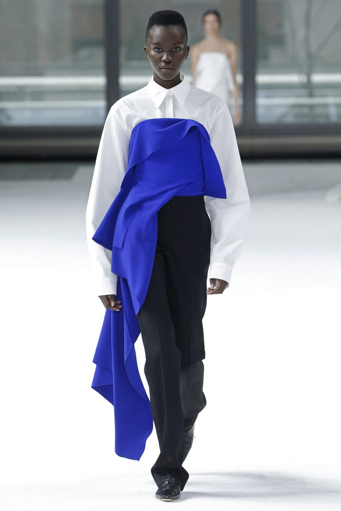 Carolina Herrera white button down shirt with nautilus navy fluid crepe corset overlay, black wool straight leg pant, black lace-up brogue. (Photo courtesy of Carolina Herrera)