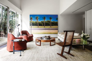 Reading area of the Tree House’s Grand Hall punctuated by a Woody Gwyn painting of palm trees, one of the artist’s rare Houston scenes; acquired from Meredith Long & Company. George Nakashima Conoid chair, acquired posthumously from the artist’s studio in New Hope, Pennsylvania. Stendig Atlas three-seat sofa, chairs by Italian designers, the Scarpas. (Photo by Pär Bengtsson)
