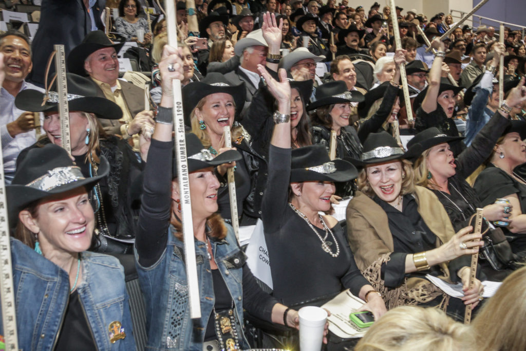 The Champagne Cowgirls raising their hands and their bid to buy Buying Grand Champion Steer in 2016