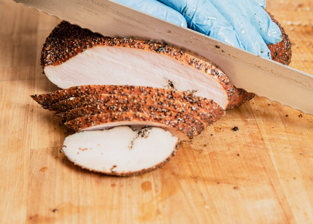 Slicing smoked and peppered turkey.