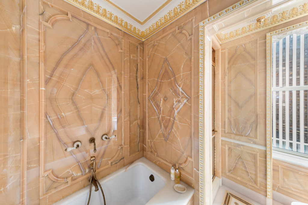 Guest baths are elegantly outfitted in vast expanses of marble. (Photo courtesy Douglas Elliman )