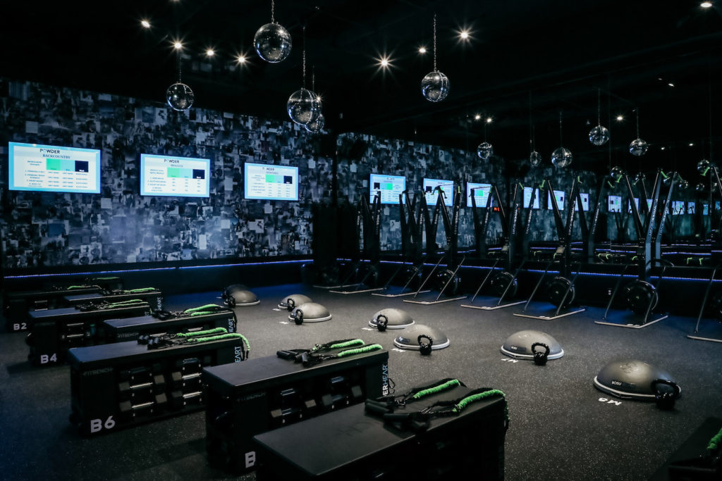 Screens help guide you through the rigorous HIIT workout in the dimly lit, loud music and disco-ball filled space. 