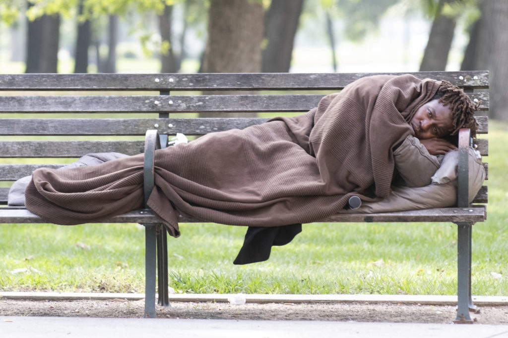 A man lies on a park bench across from Ben Taub Hospital. Houston's homeless will be more exposed than ever during this coronavirus pandemic. (Photo by F. Carter Smith)